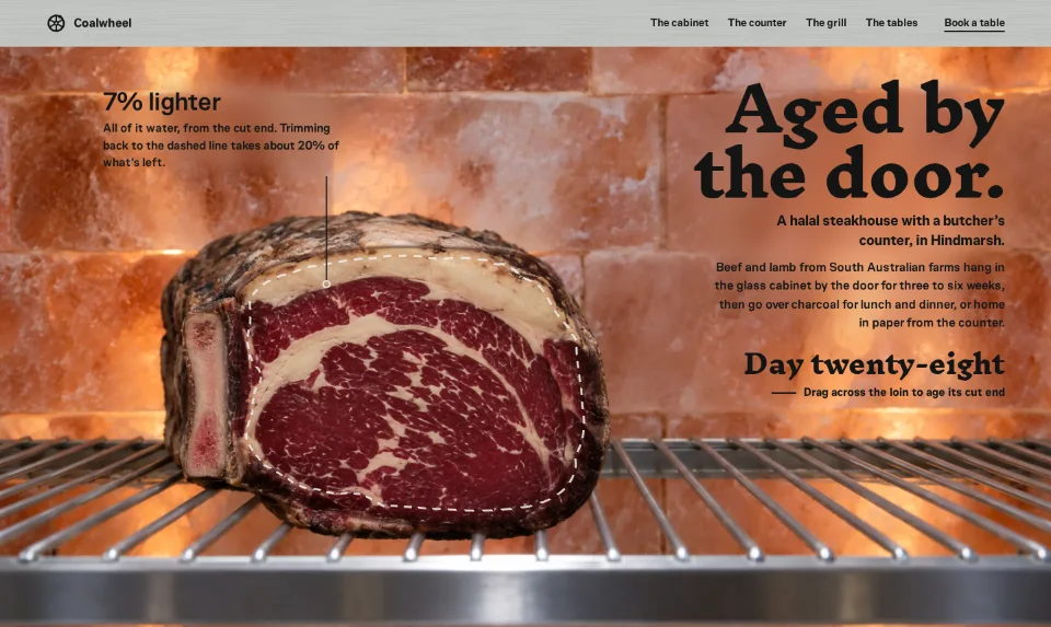 The front page: the end of a rib-eye loin on a steel rack in the ageing cabinet, before a glowing salt-block wall