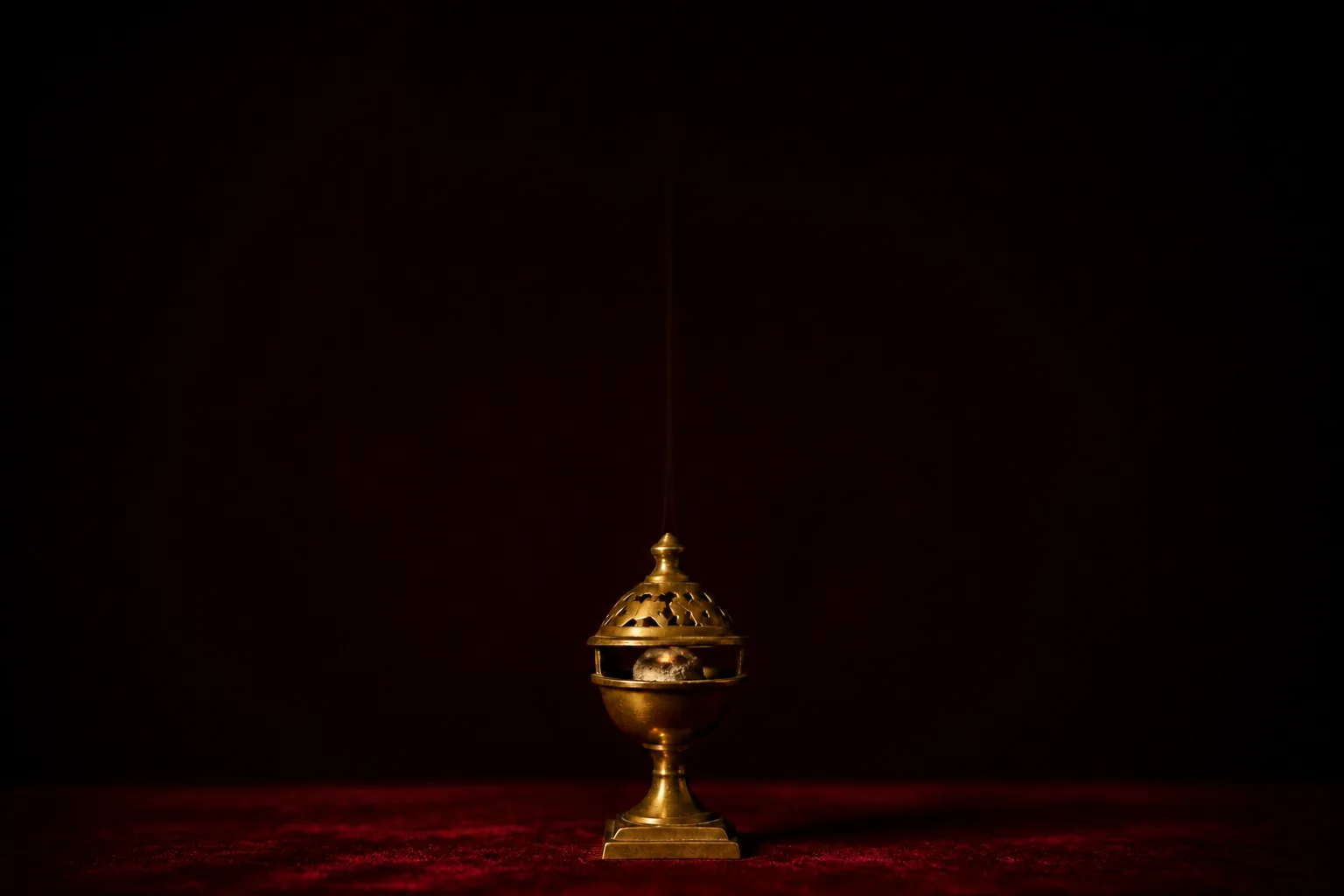 The same brass burner at the end of the evening, the coal gone to grey ash and one faint thread of smoke.