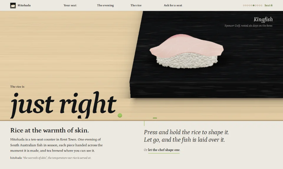 The front page: a finished piece of kingfish nigiri on a black board above a pale timber counter edge