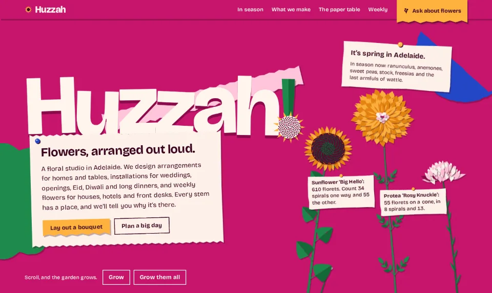 Huzzah's front page: the name in chunky cream cut-out letters on hot magenta, paper flowers growing up behind a pinned cream slip