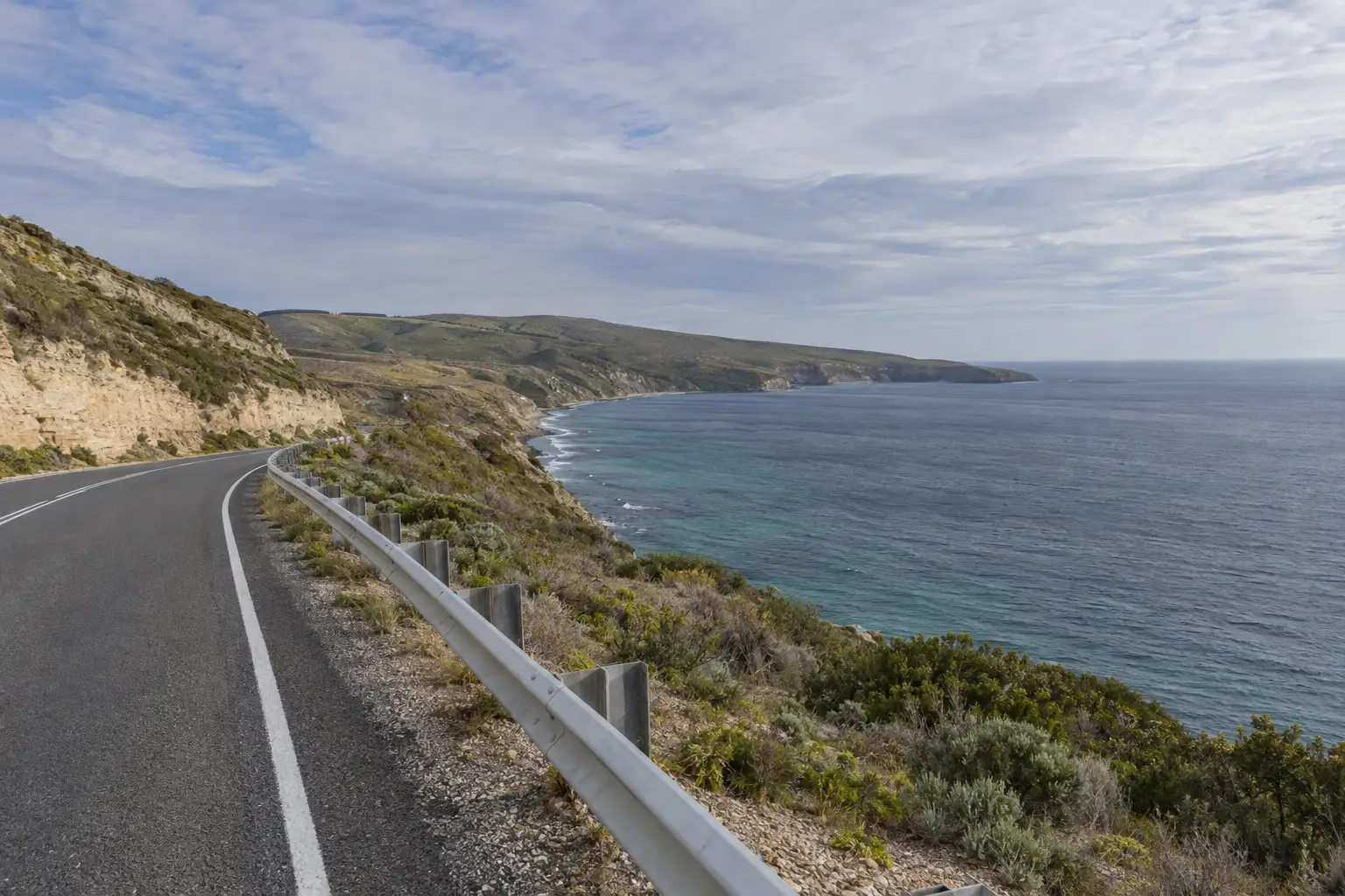 The coast road along the headland above the bay on a clear winter morning.