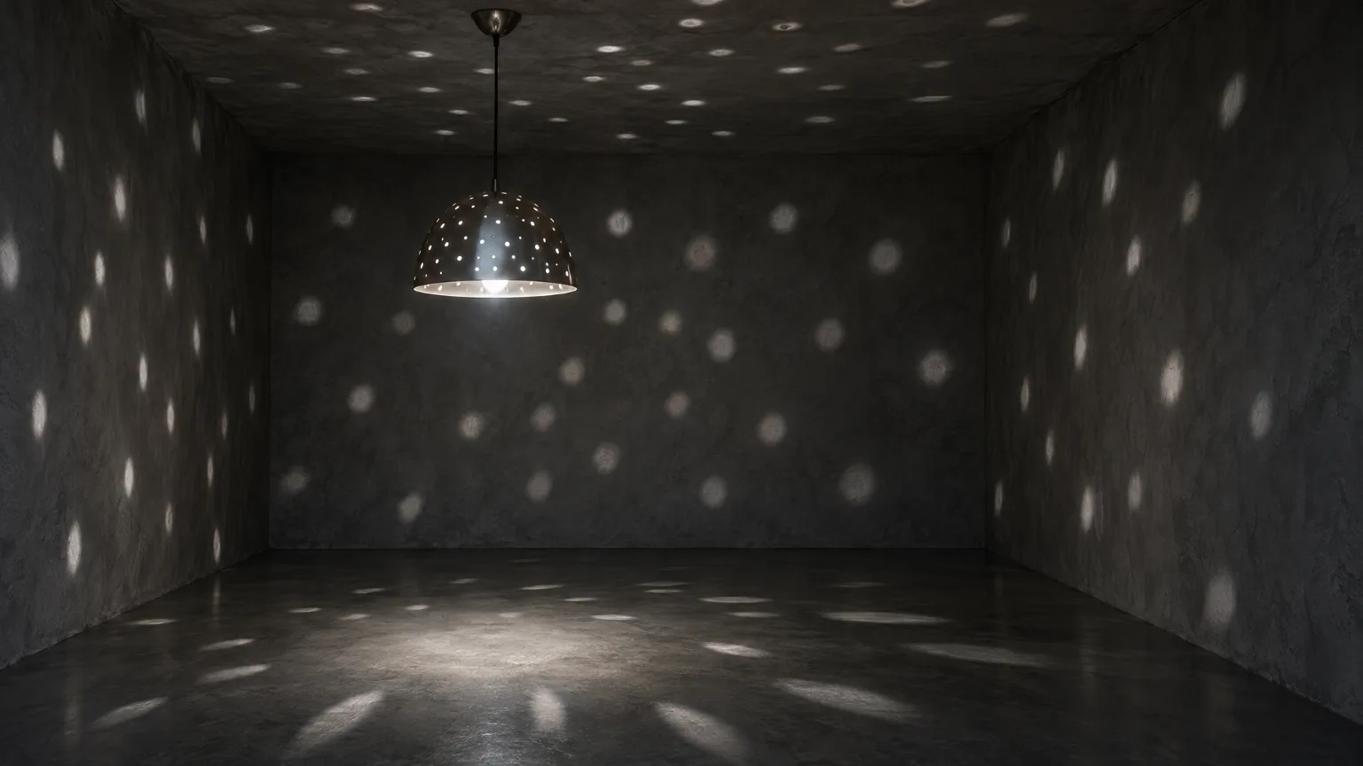 A pierced steel shade hanging in a small dark plaster room, scattering points of cool white light over the walls, ceiling and floor