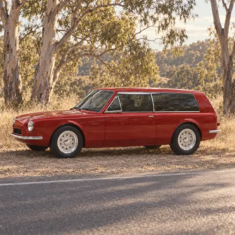 The shooting brake side-on at the edge of a country road under gum trees
