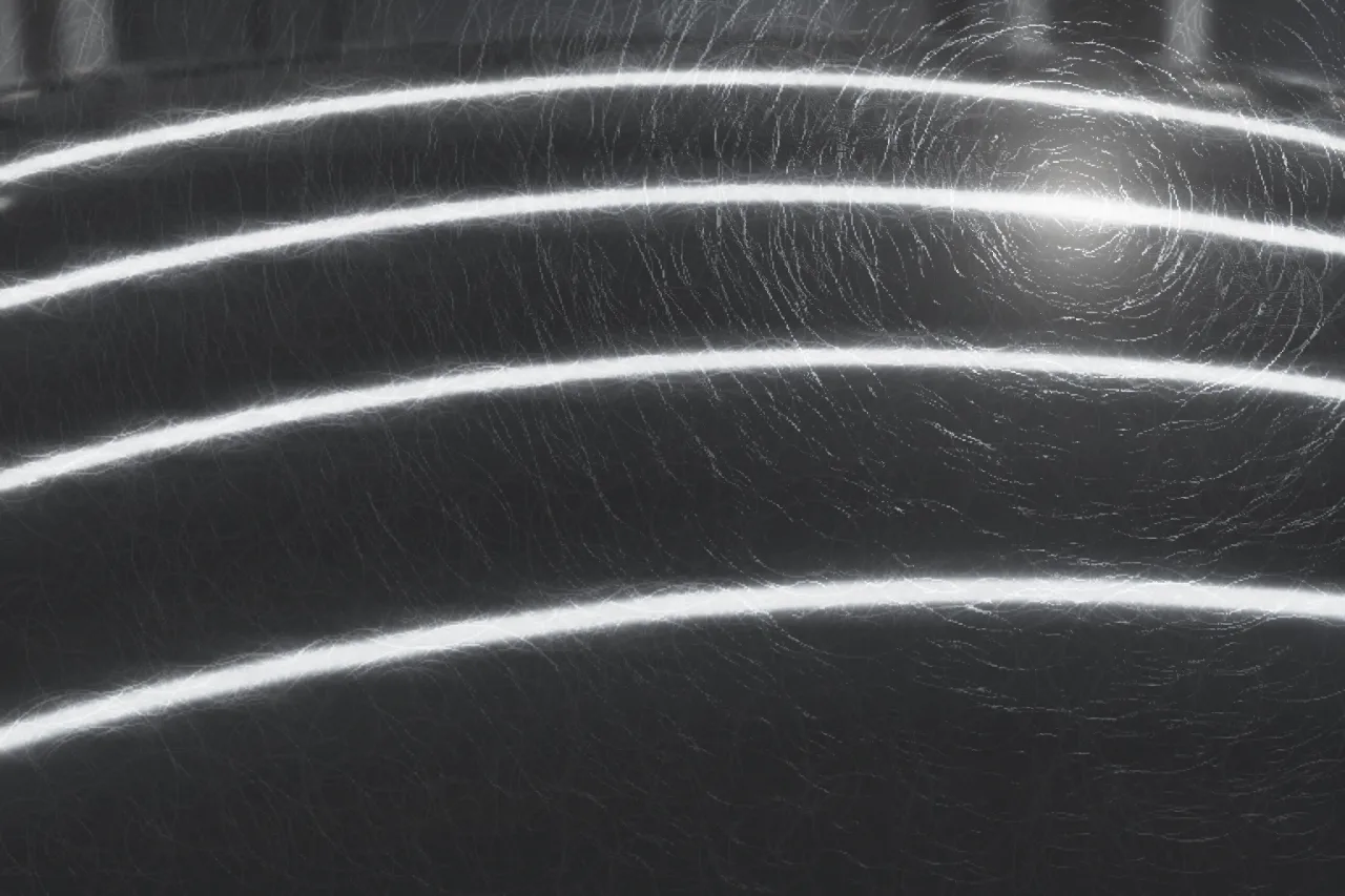 The same black bonnet before polishing: grey and dull, the strip lights blurred, fine circular swirl marks all over it.