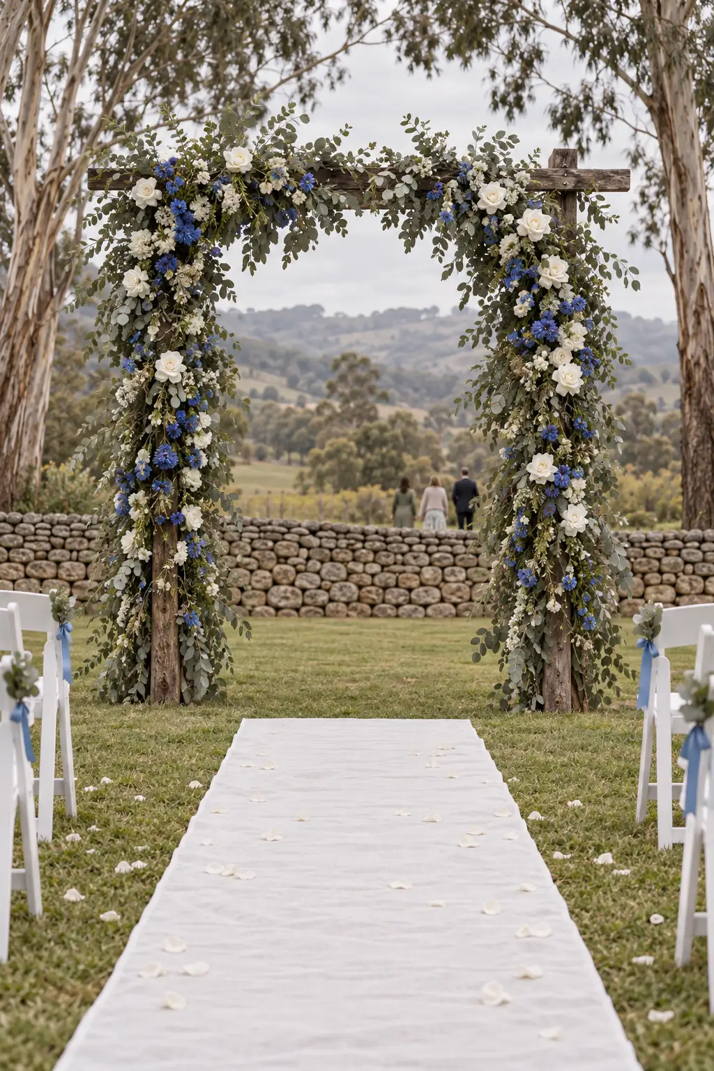 The arbour at the end of the aisle, wrapped in gum leaves, white roses and cornflowers.