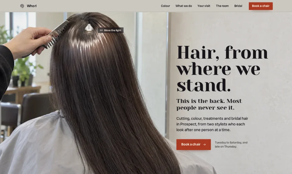 The front page: long dark hair from behind, a pendant lamp over the crown with its band of shine just under it, and the headline on the plaster beside it
